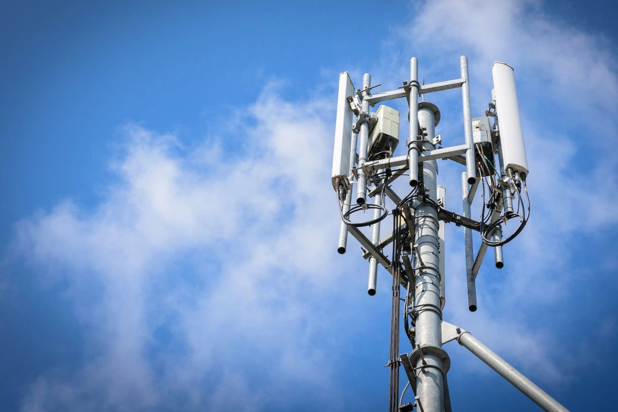 A cell phone tower with many antennas on it.